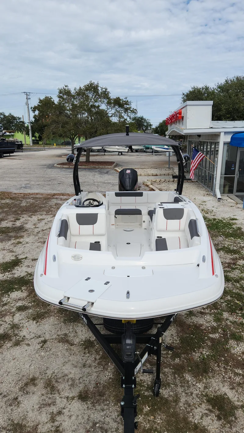 Slide: The Image of 2023 Tahoe 1950 boat on trailer, parked outdoors, with overcast sky. - 5