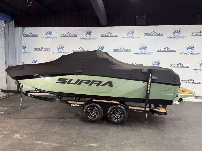 Slide: The Image of 2023 Supra SA 550 boat with cover on trailer in showroom. - 44