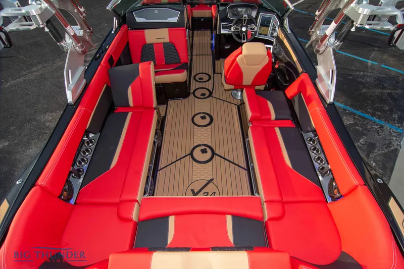 Slide: The Image of 2021 MasterCraft X24 boat interior with red and black seating, advanced dashboard, and teak flooring. - 13
