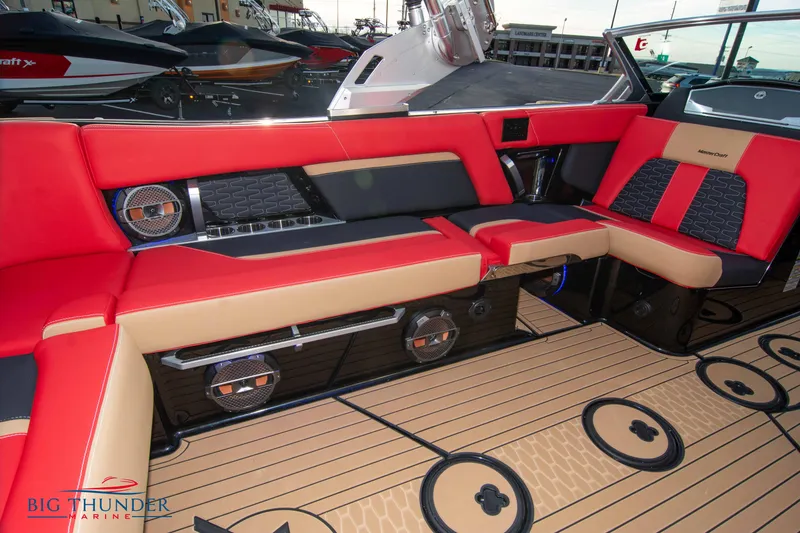 Slide: The Image of 2021 MasterCraft X24 boat interior with red and beige seating and premium sound system. - 16