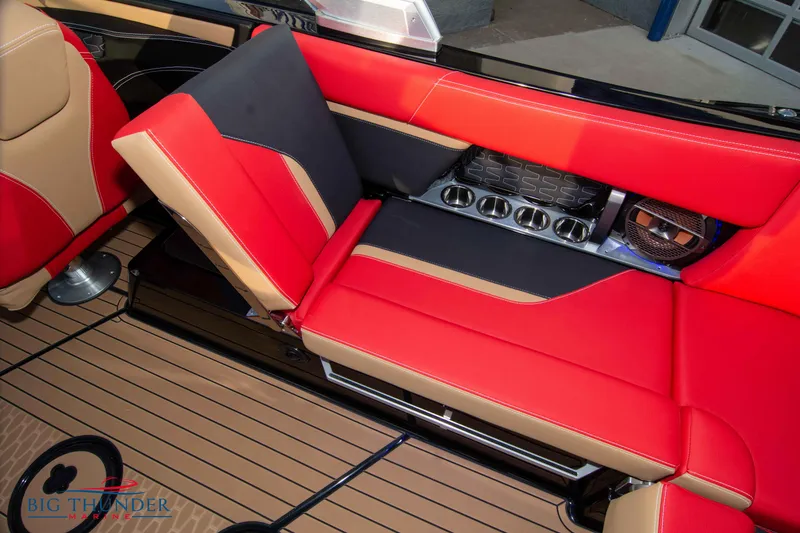 Slide: The Image of 2021 MasterCraft X24 boat interior with red and black seating and cup holders. - 33
