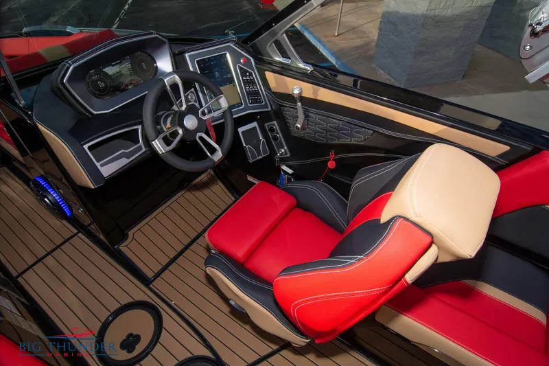 Slide: The Image of 2021 MasterCraft X24 boat interior with red and beige captain's seat and advanced dashboard. - 49