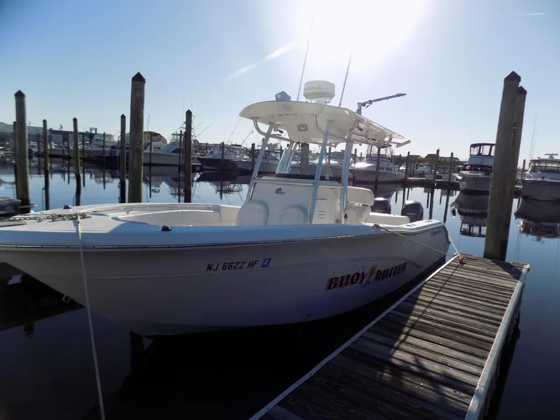 Slide: The Image of 2012 Sea Fox 256 Commander boat docked at marina under clear sky. - 2