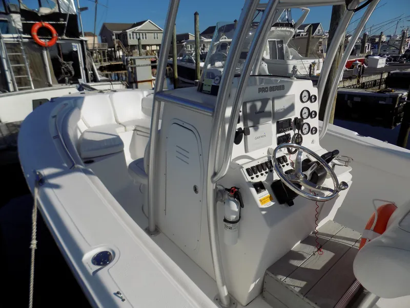 Slide: The Image of 2012 Sea Fox 256 Commander boat interior with steering console and seating at marina. - 6