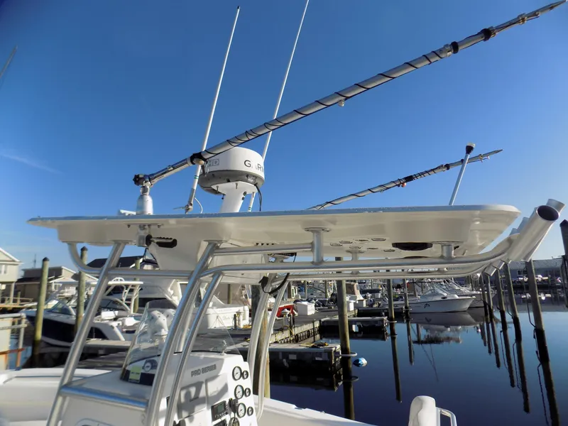 Slide: The Image of 2012 Sea Fox 256 Commander boat with fishing rods and radar, docked at a marina. - 8