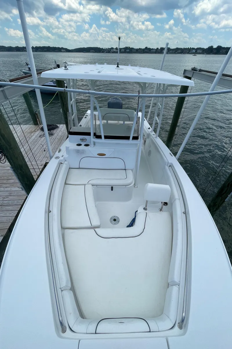 Slide: The Image of 2015 Sea Hunt Edge 24 boat docked at a marina, view of the deck and seating area. - 2