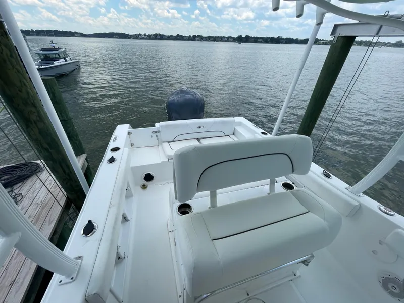 Slide: The Image of 2015 Sea Hunt Edge 24 boat with white seating, docked on a calm lake. - 21