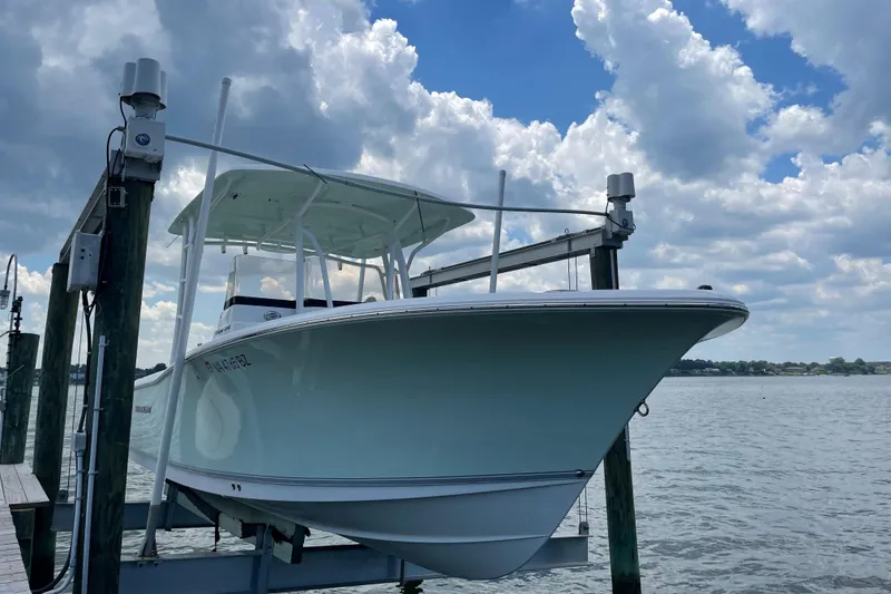 Slide: The Image of 2015 Sea Hunt Edge 24 boat docked on a lift with a cloudy sky background. - 23