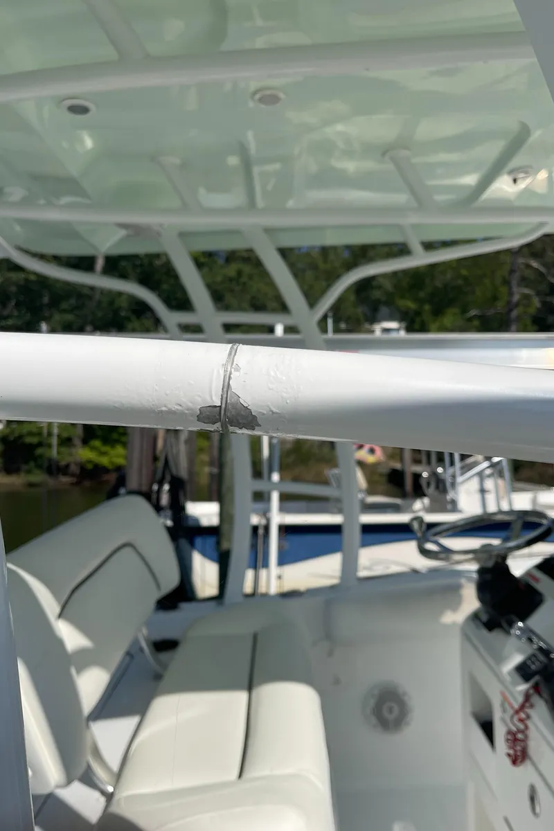 Slide: The Image of 2015 Sea Hunt Edge 24 boat with visible damage on the railing. - 24