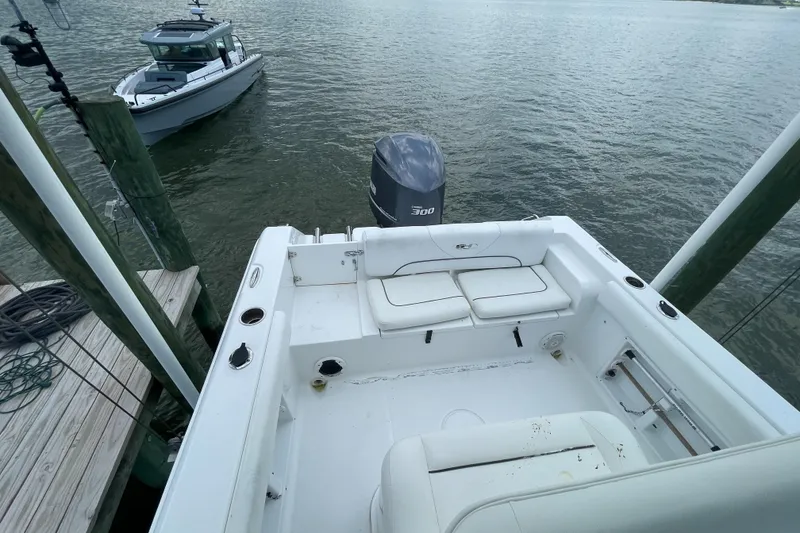 Slide: The Image of 2015 Sea Hunt Edge 24 boat docked, showing spacious seating and outboard motor. - 5