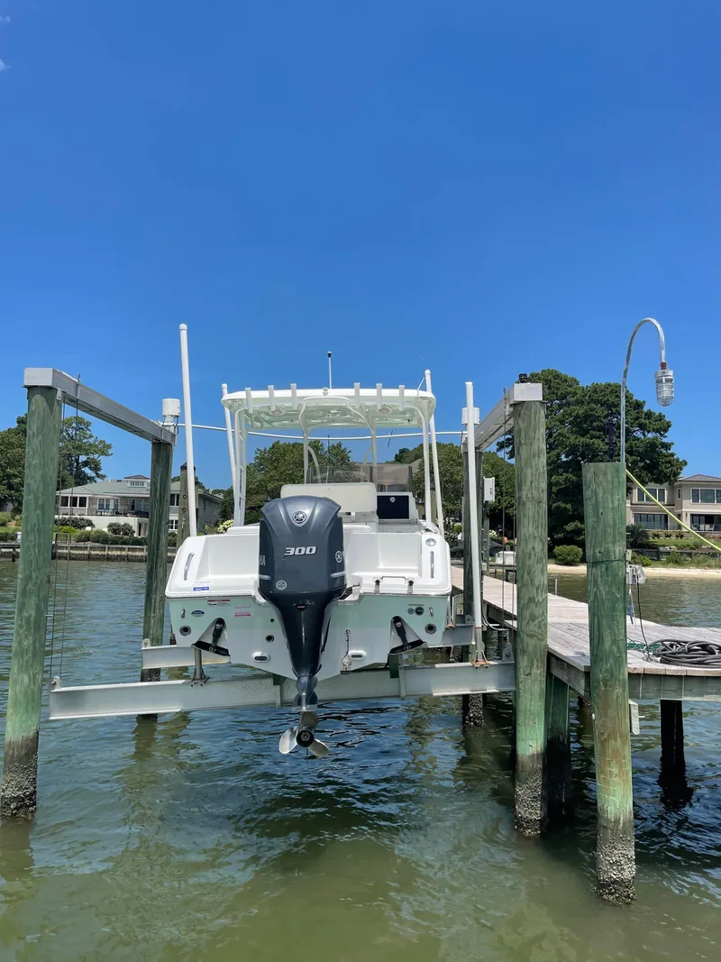Slide: The Image of 2015 Sea Hunt Edge 24 boat on a lift at a dock. - 9