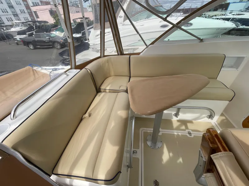 Slide: The Image of 2004 Hunt Yachts Surfhunter 29 with tan canopy, docked at a marina. - 7