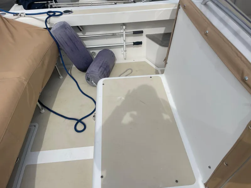 Slide: The Image of 2004 Hunt Yachts Surfhunter 29 boat interior with beige seating and blue rope. - 9