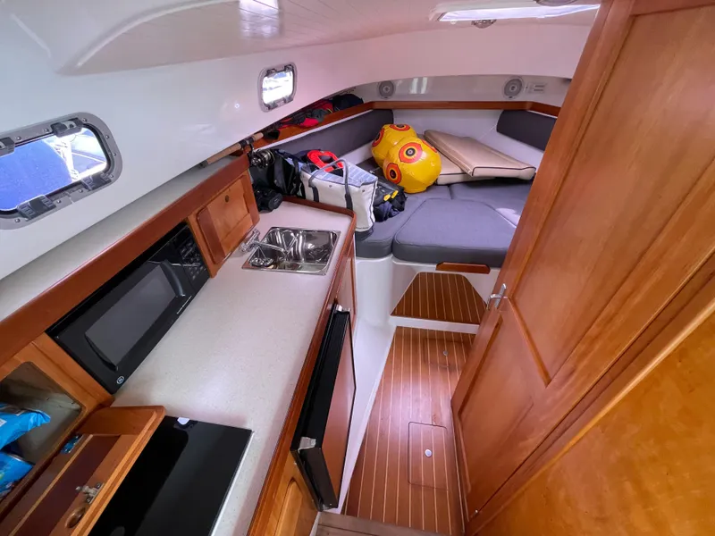 Slide: The Image of Cozy cabin interior of 2004 Hunt Yachts Surfhunter 29 with cushions and gear. - 12