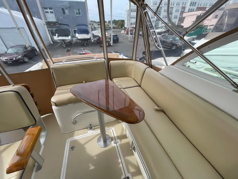 Slide: The Image of 2004 Hunt Yachts Surfhunter 29 interior with beige seating and wooden table. - 4