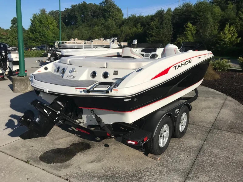 Slide: The Image of 2023 Tahoe 210 Si Limited boat on a trailer, parked outdoors. - 1