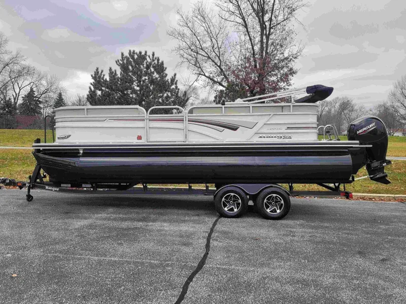 The Image of 2023 Ranger Reata 223C pontoon boat on trailer in a park setting. - 0