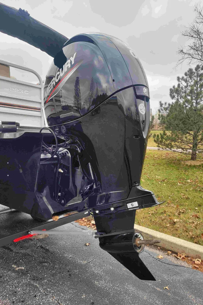 Slide: The Image of 2023 Ranger Reata 223C with Mercury outboard motor in a parking lot. - 5