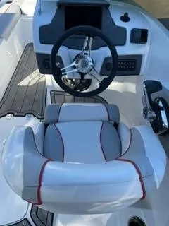 Slide: The Image of 2023 Tahoe 210 Si Limited boat cockpit with steering wheel and cushioned seat. - 10