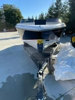 Slide: The Image of 2023 Tahoe 210 Si Limited boat on trailer, parked outdoors. - 2