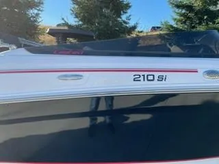 Slide: The Image of 2023 Tahoe 210 Si Limited boat with sleek design and red accents. - 3