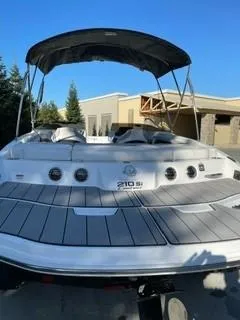 Slide: The Image of 2023 Tahoe 210 Si Limited boat with canopy, docked outdoors. - 6