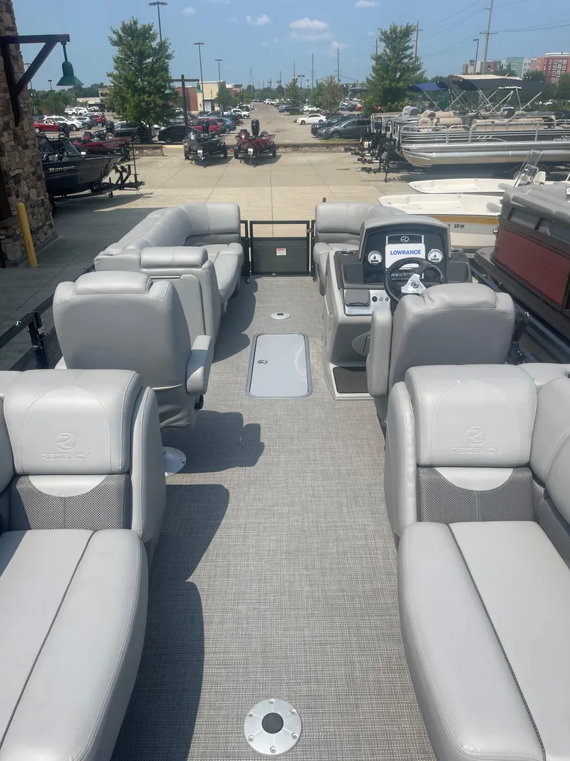Slide: The Image of 2023 Regency 230 DL3 pontoon boat with spacious seating and modern dashboard. - 2
