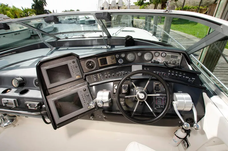 Slide: The Image of 1993 Sea Ray Sundancer boat cockpit with navigation equipment and steering wheel. - 13