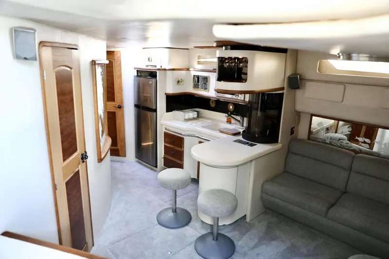 Slide: The Image of 1993 Sea Ray Sundancer interior with kitchen, seating area, and modern amenities. - 16