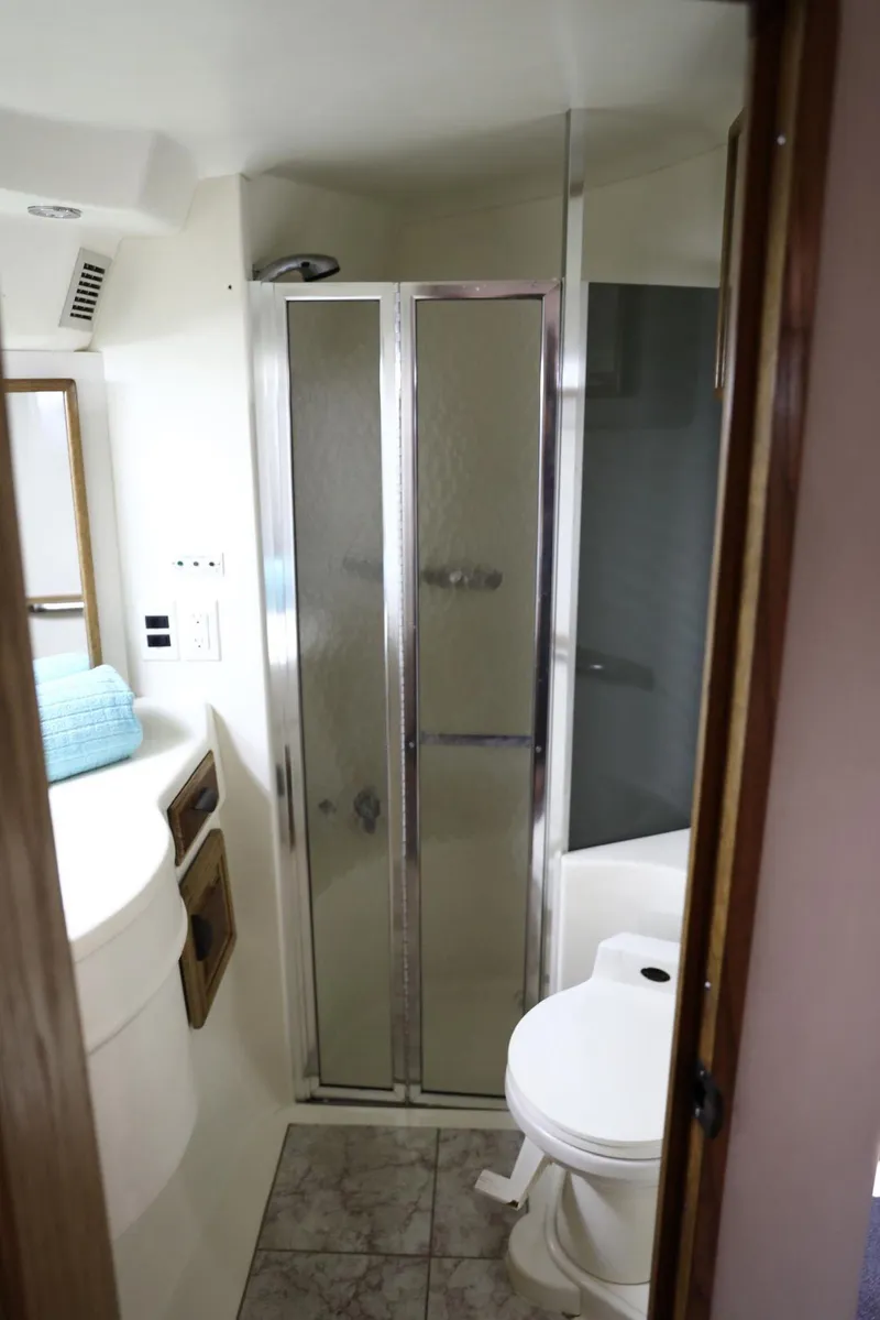 Slide: The Image of Bathroom interior of a 1993 Sea Ray Sundancer yacht with shower and toilet. - 24