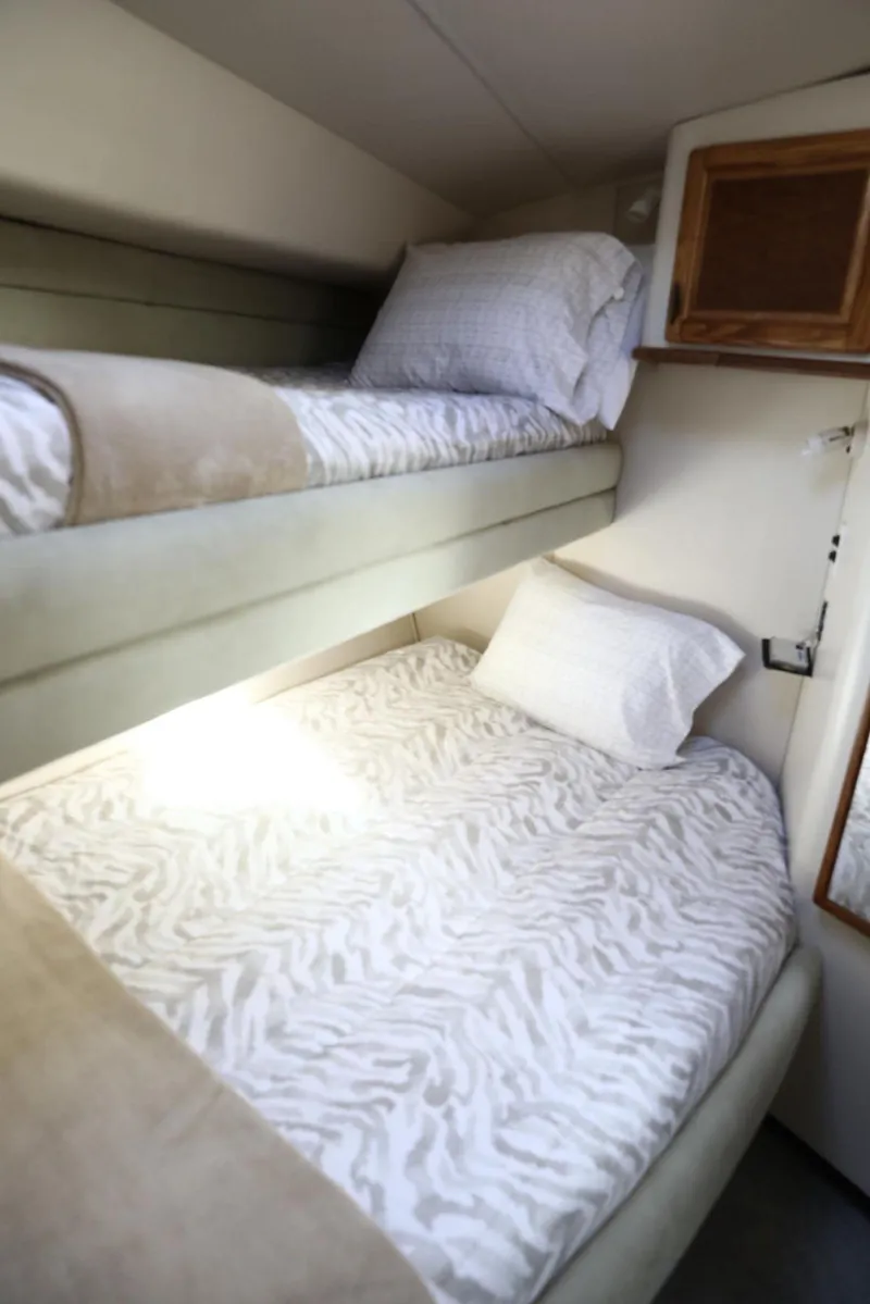Slide: The Image of 1993 Sea Ray Sundancer cabin with cozy bunk beds and zebra-patterned bedding. - 25