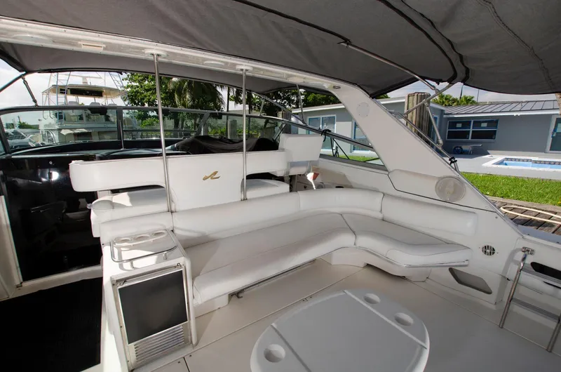 Slide: The Image of 1993 Sea Ray Sundancer boat interior with white seating and shaded deck. - 6