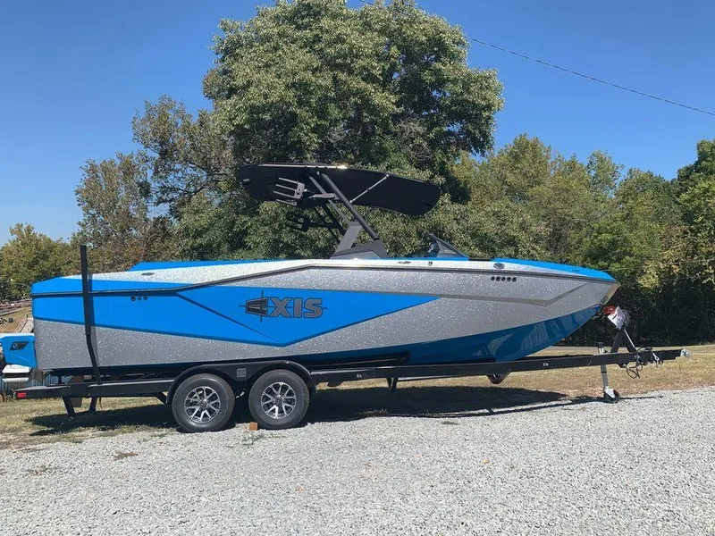 Slide: The Image of 2023 Axis T250 boat on trailer, blue and gray, parked outdoors. - 1