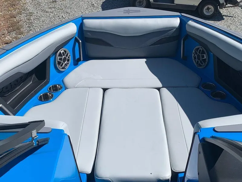 Slide: The Image of 2023 Axis T250 boat interior with blue and gray seating, cup holders, and speakers. - 12