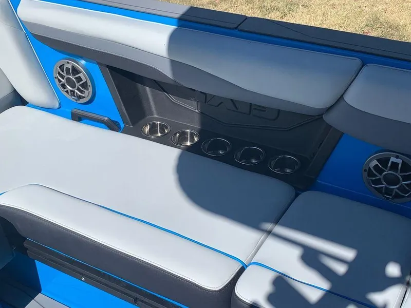Slide: The Image of 2023 Axis T250 boat interior with gray and blue seating, cup holders, and speakers. - 9