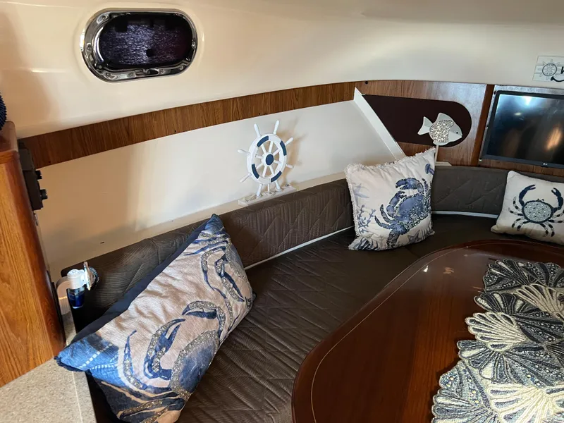 Slide: The Image of Interior of 2014 Pursuit 345 OS boat with nautical-themed decor and crab pillows. - 16