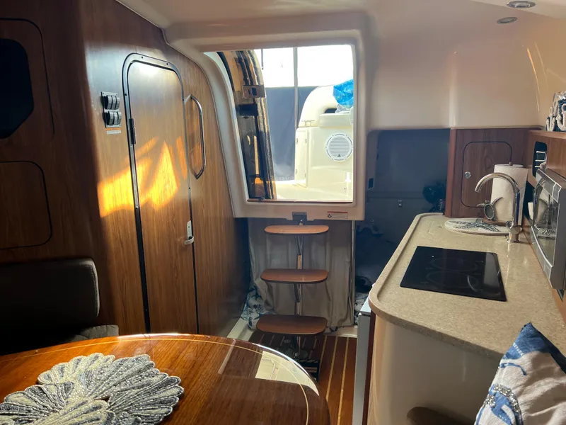 Slide: The Image of Interior of 2014 Pursuit 345 OS boat with kitchen and dining area. - 17