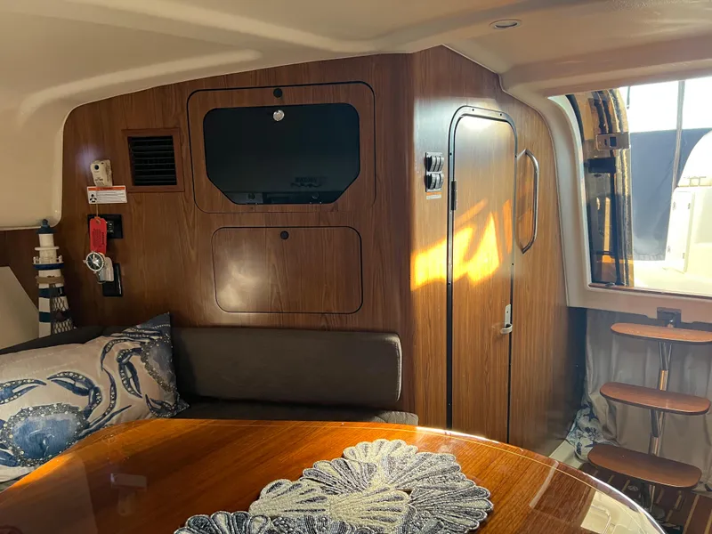 Slide: The Image of Interior cabin of a 2014 Pursuit 345 OS boat with wooden finishes and seating area. - 18
