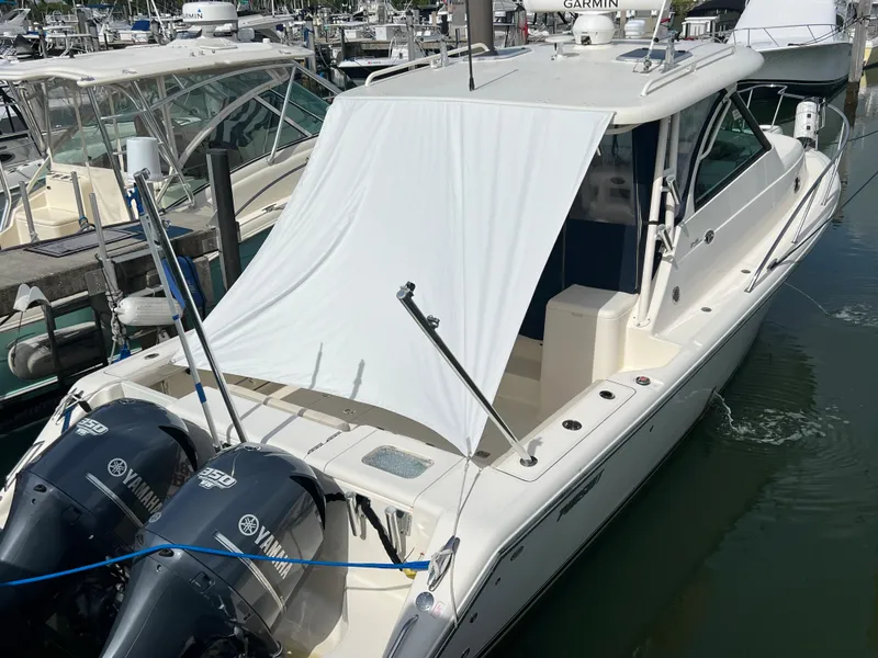 Slide: The Image of 2014 Pursuit 345 OS boat docked with twin Yamaha engines. - 2