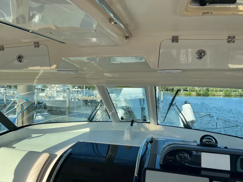 Slide: The Image of Interior view of 2014 Pursuit 345 OS boat cockpit with marina background. - 35