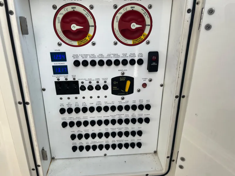 Slide: The Image of Control panel of a 2014 Pursuit 345 OS boat with switches and gauges. - 42