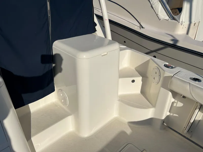 Slide: The Image of 2014 Pursuit 345 OS boat interior with white seating and storage compartment. - 47