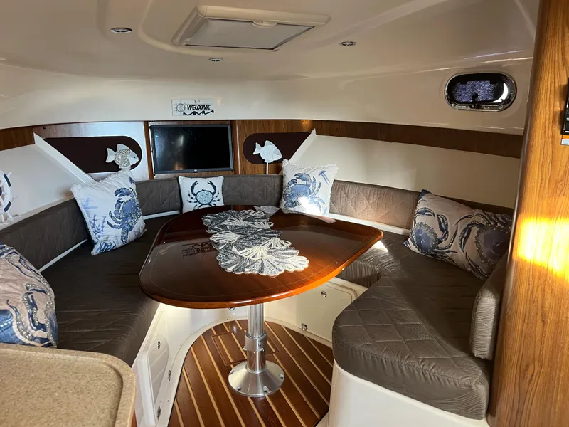 Slide: The Image of Interior of 2014 Pursuit 345 OS boat with cozy seating and wooden table. - 9