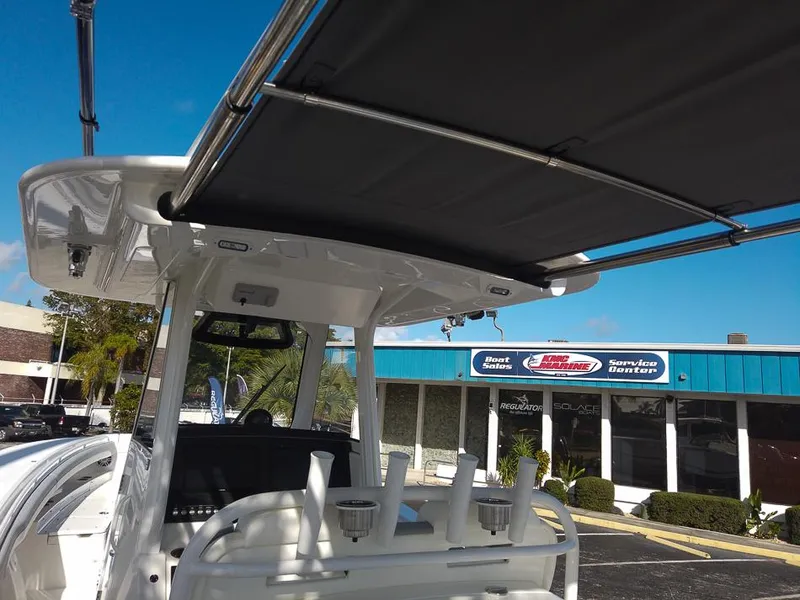 Slide: The Image of 2024 Regulator 31 boat with T-top and rod holders at a dealership. - 10