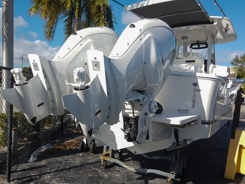 Slide: The Image of 2024 Regulator 31 boat with dual outboard engines, docked under palm trees. - 8