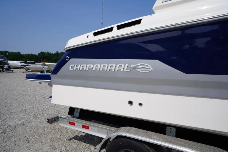 Slide: The Image of 2025 Chaparral 267 SSX boat on trailer, side view, outdoors. - 2