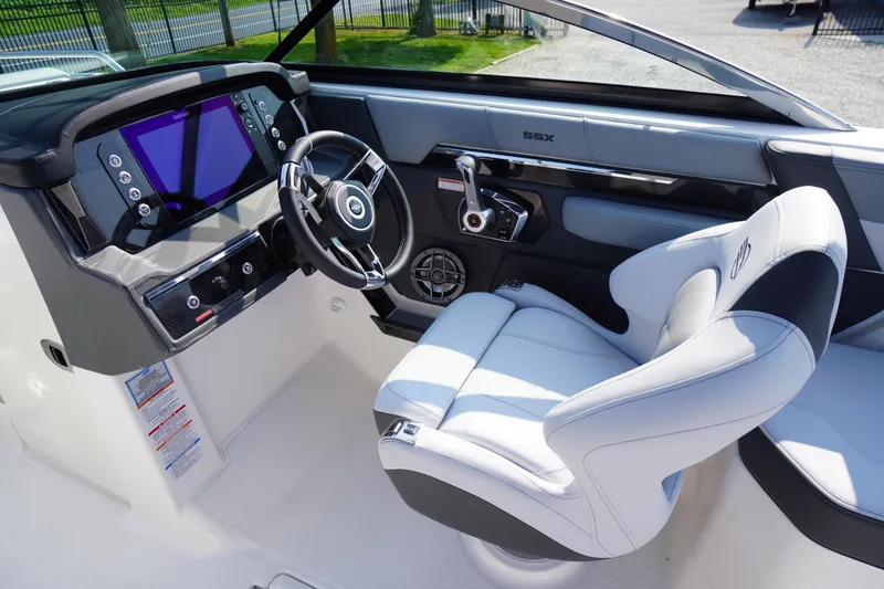 Slide: The Image of 2025 Chaparral 267 SSX boat interior with luxurious white captain's seat and modern steering wheel. - 35