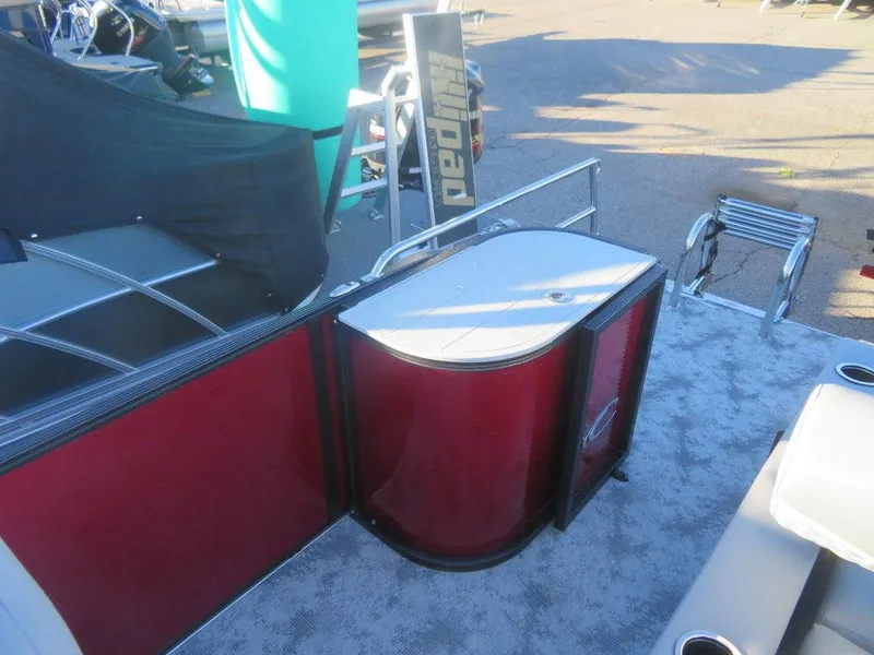 Slide: The Image of 2023 Crest Classic DLX 220 SLSC CPT DLX pontoon boat interior with red paneling. - 12