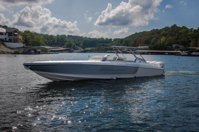 Slide: The Image of 2019 Donzi 41 GT boat cruising on a scenic lake under a partly cloudy sky. - 6