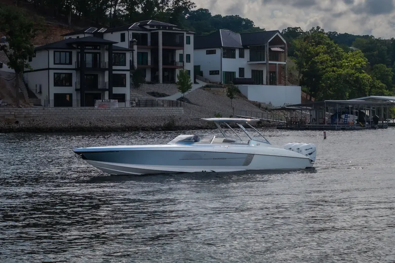 Slide: The Image of 2019 Donzi 41 GT boat cruising near modern waterfront homes. - 2